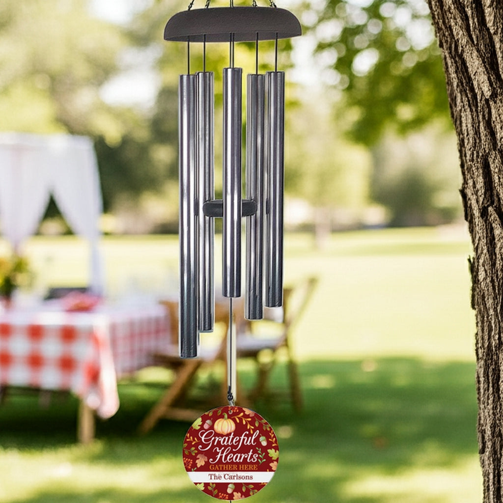 Personalized wind chime gift with metal tubes and custom engraved plaque hanging from tree