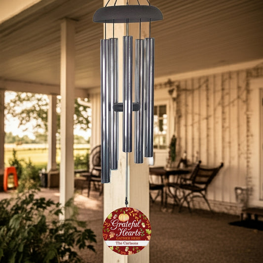 Personalized wind chime with gratitude message hanging on porch post