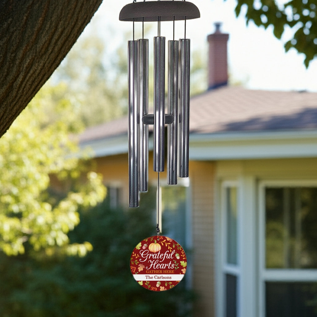 Personalized wind chime gift hanging from tree with grateful hearts design and custom family name