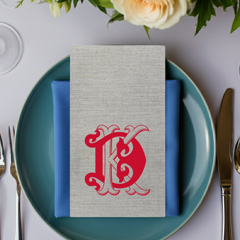 Elegant Tippytoad premium linen feel guest towel napkins in gray with red monogram design on a blue plate