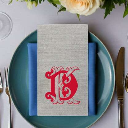Elegant Tippytoad premium linen feel guest towel napkins in gray with red monogram design on a blue plate