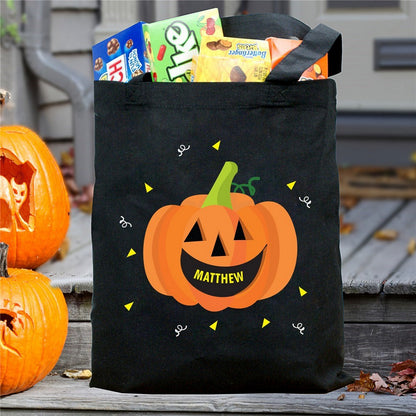 Black tote with smiling jack o lantern and name Matthew filled with candy pumpkin personalized trick or treat bag