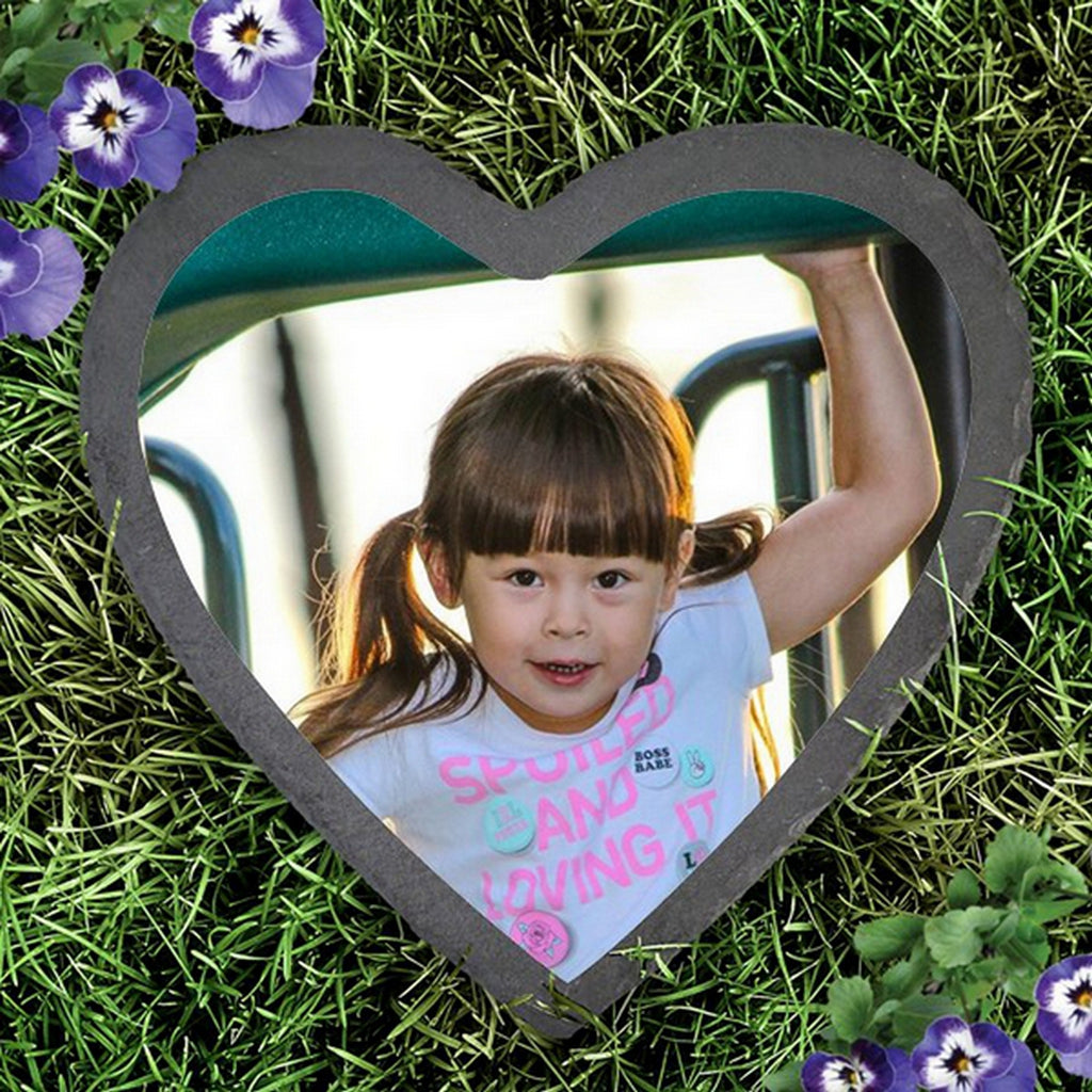 Slate heart photo garden stone with a child's picture surrounded by green grass and purple flowers