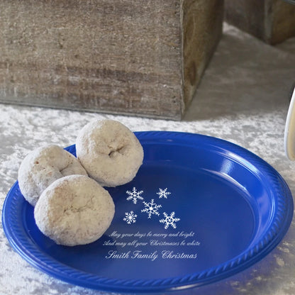 Powdered donuts on a blue plastic dessert plate personalized with winter snowflakes design and custom message in white print.