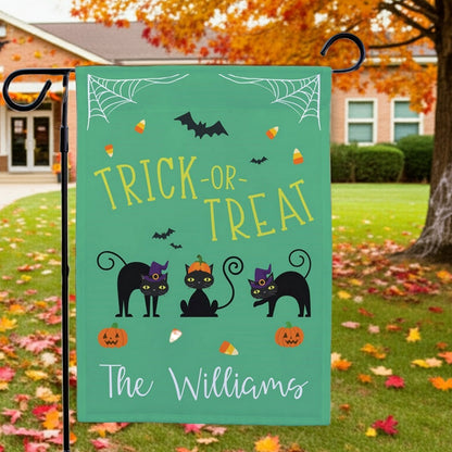 Halloween garden flag green Trick or Treat design with three black cats pumpkins and candy corn