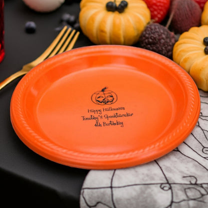 Orange plastic plate with pumpkin logo and custom text on black table personalized plastic Halloween appetizer and dessert plates