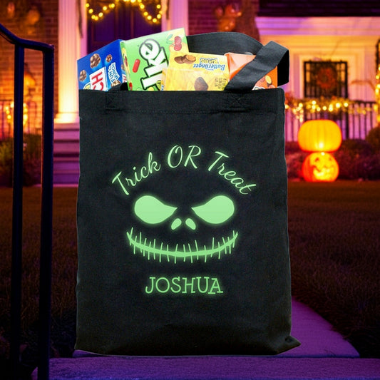 Glow in the dark monster personalized trick or treat bag with green glowing face and Joshua filled with candy