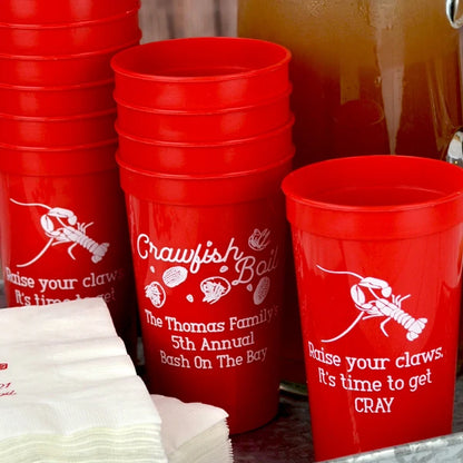 Red 22 oz. stadium cups personalized with crawfish boil design and custom text on front side and crawfish design and custom text on back side in white print