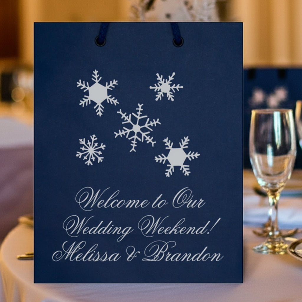 Navy Christmas gift bags featuring snowflakes and a welcome message for wedding celebrations