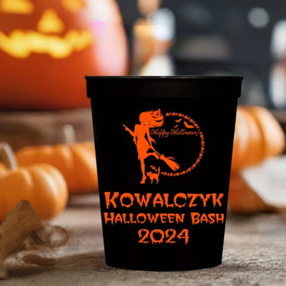 Sexy witch with broom and cat next to a pumpkins and skulls moon clipart design and 3 lines of text in orange print on personalized Halloween stadium cups