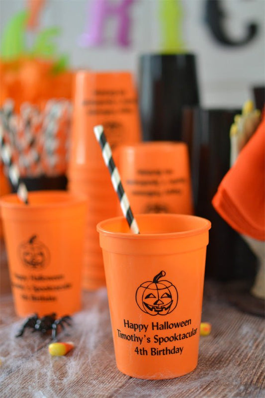 Orange 12 ounce drink cups for kids personalized with 'Jack-O-Lantern' Halloween design and three line of text in black imprint color for Halloween birthday party