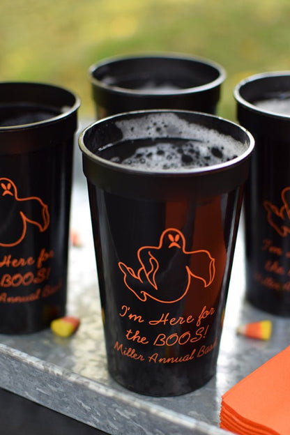 22 Oz. black stadium cups personalized with 'Ghost' Halloween design and 3 lines of text in orange imprint color