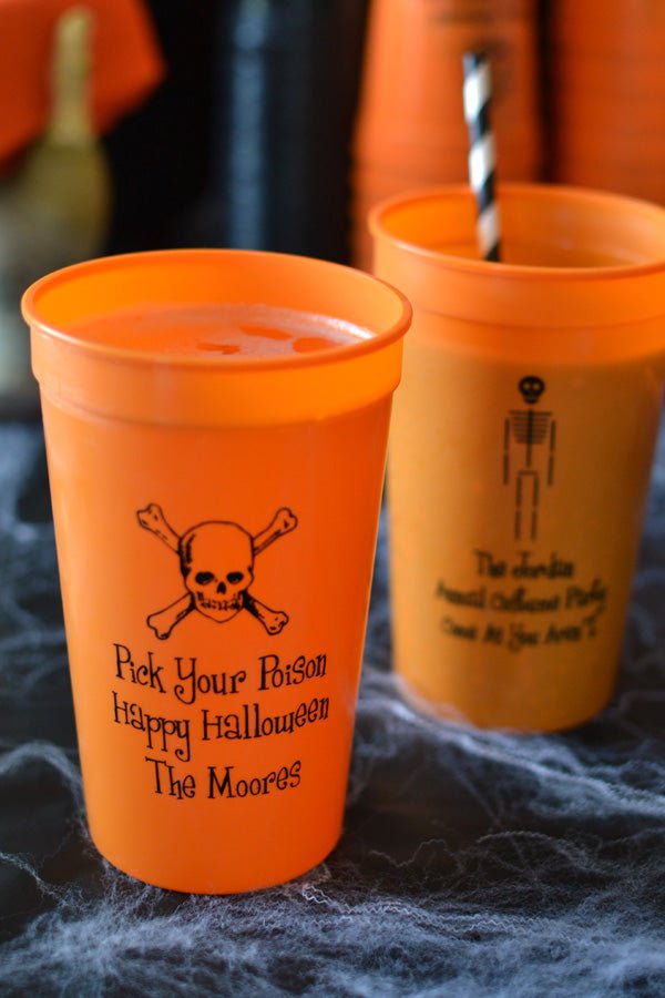 22 Oz. orange stadium cups personalized with 'Skull & Crossbones' design and 3 lines of text on the fron and 'Skeleton' Halloween design on the back with three lines of text in black imprint color